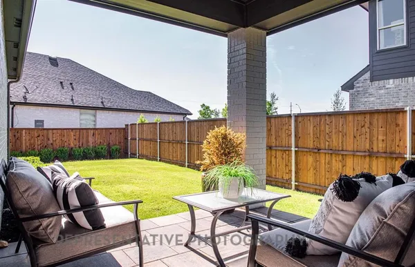 a view of a patio with table and chairs and potted plants