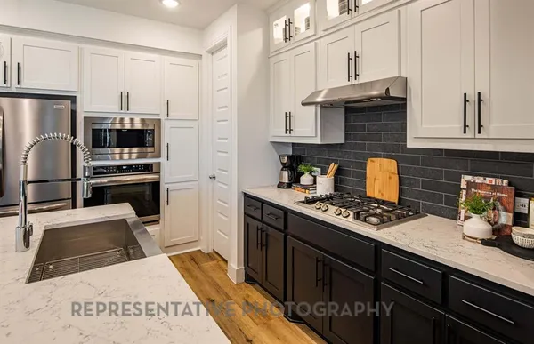 a kitchen with stainless steel appliances granite countertop a stove refrigerator and a microwave