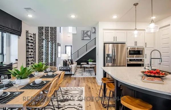 a kitchen with stainless steel appliances granite countertop a refrigerator a stove and a wooden floors