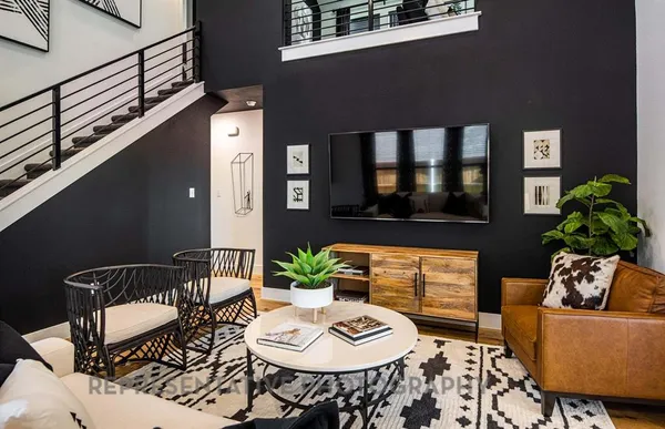 a living room with furniture and a potted plant