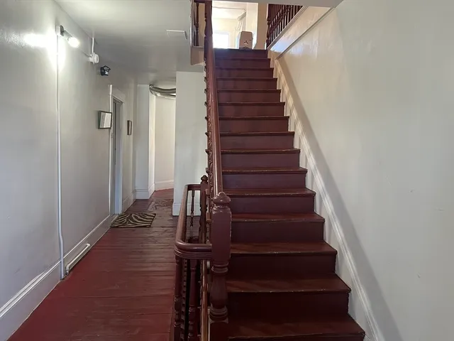 a view of entryway and gallery with wooden floor