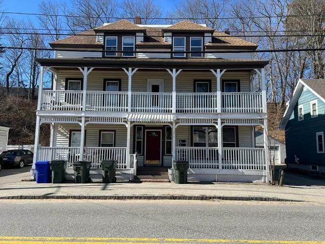 a front view of a house with a garden and plants