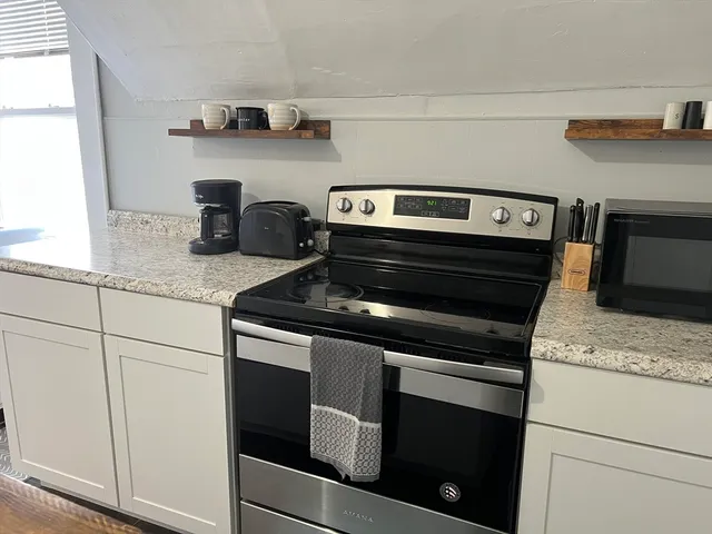 a kitchen with granite countertop stainless steel appliances and white cabinets