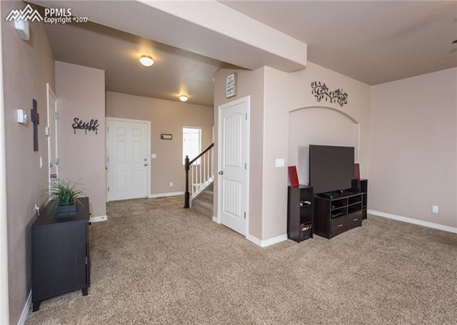 2105 Reed Grass Way Colorado Springs, CO 80915 - Photo 1 of 23 Open and inviting main level. The door next to the stairs leads to the large unfinished basement.