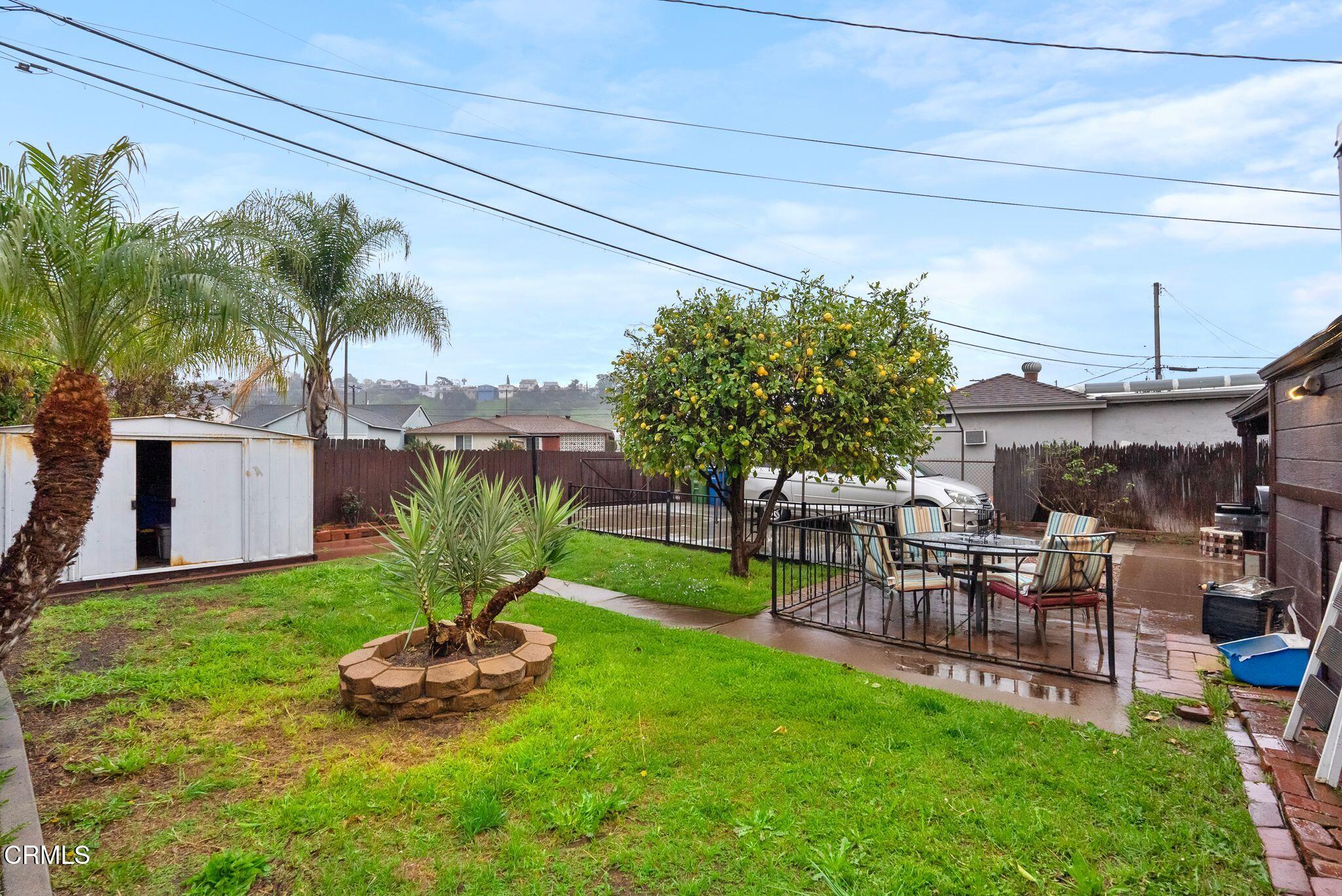 2102 North Eastern Avenue Los Angeles, CA 90032 - Photo 27 of 28 a view of a backyard with table and chairs potted plants and palm tree