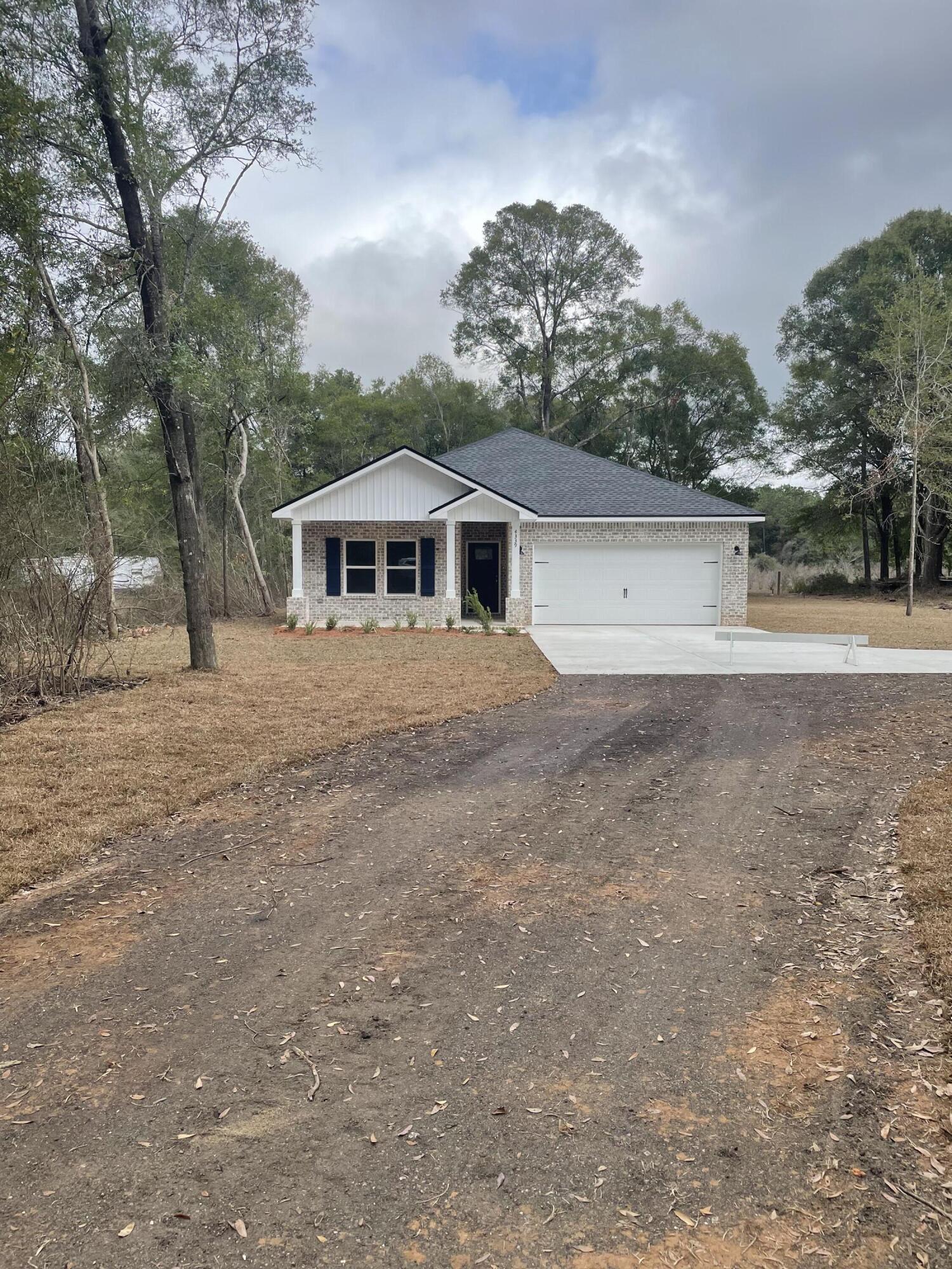 4339 Cooper Lane Holt, FL 32564 - Photo 1 of 16 a front view of a house with a yard and trees