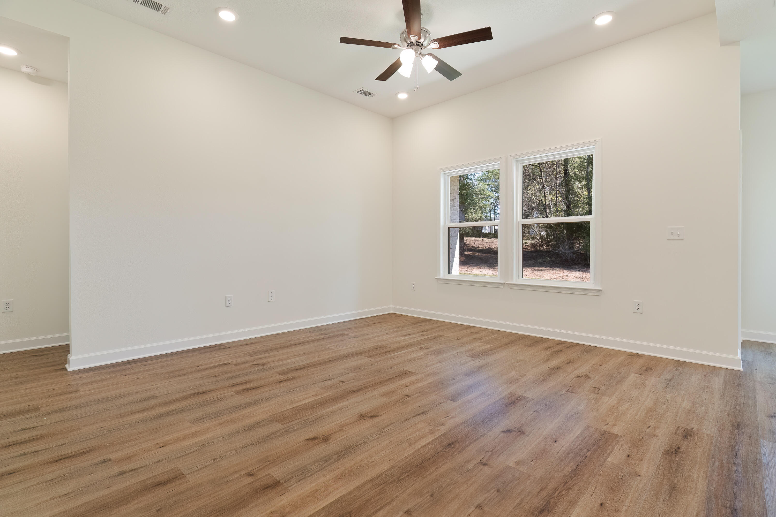 4339 Cooper Lane Holt, FL 32564 - Photo 3 of 16 an empty room with wooden floor ceiling fan and windows