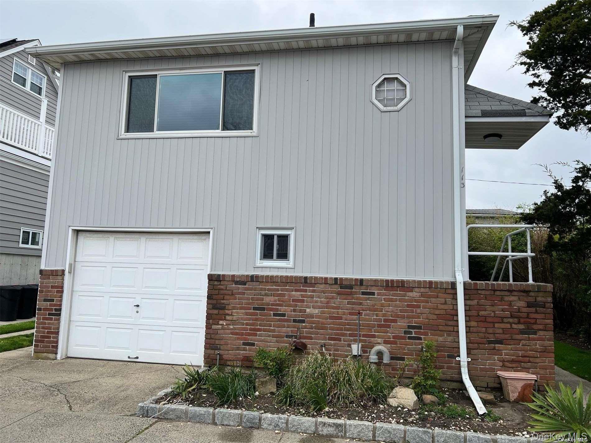 View of side of property with a garage and brick siding