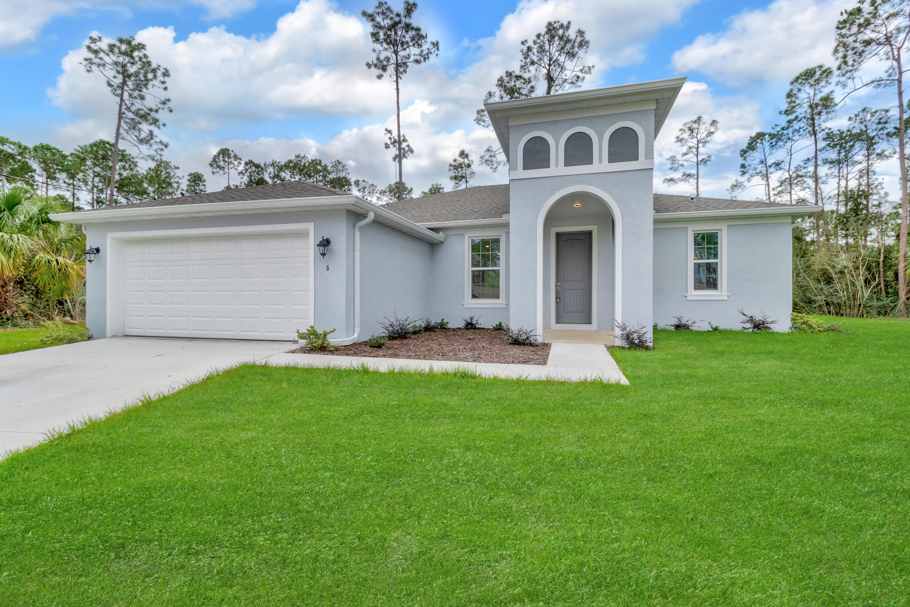 584 Octavius Road Southwest Palm Bay, FL 32908 - Photo 1 of 30 a front view of a house with a garden and plants