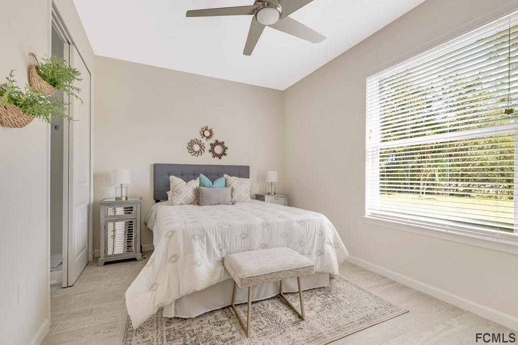 584 Octavius Road Southwest Palm Bay, FL 32908 - Photo 10 of 30 a bedroom with a bed table flowerpot and window