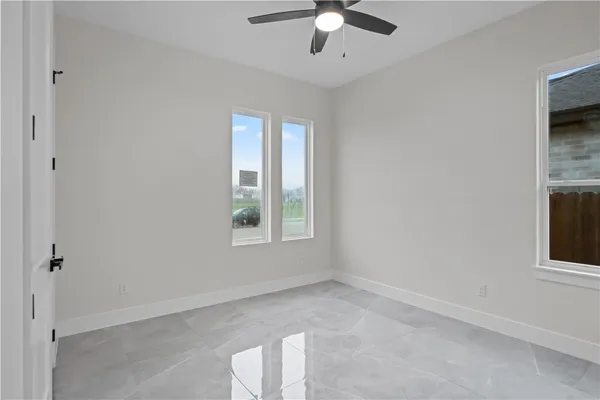 an empty room with windows and fan