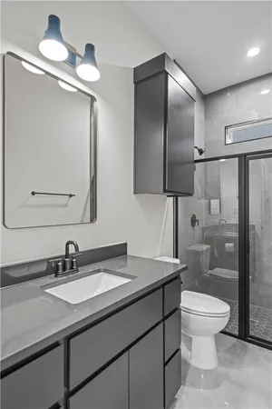 a bathroom with a toilet a sink and mirror