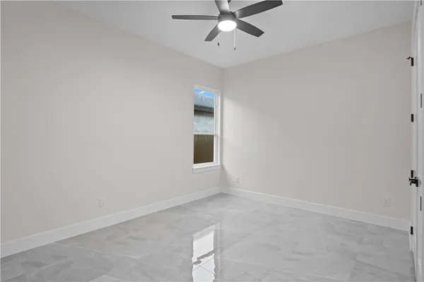 an empty room with a window and a fan