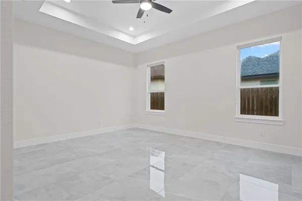 an empty room with a window and a ceiling fan