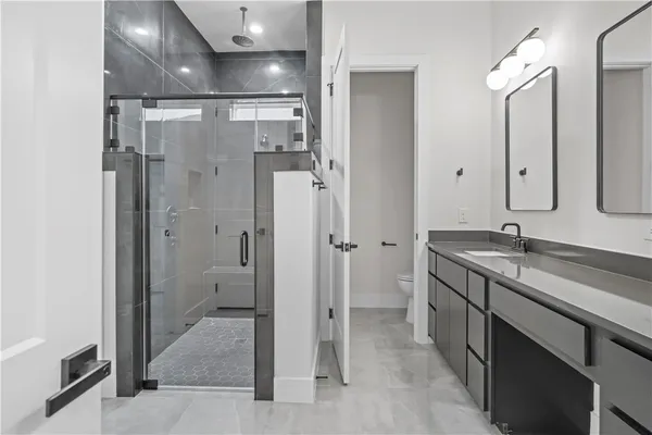 a spacious bathroom with a shower sink and mirror