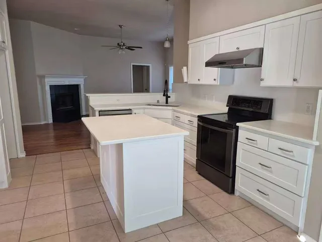 a kitchen with a stove and white cabinets