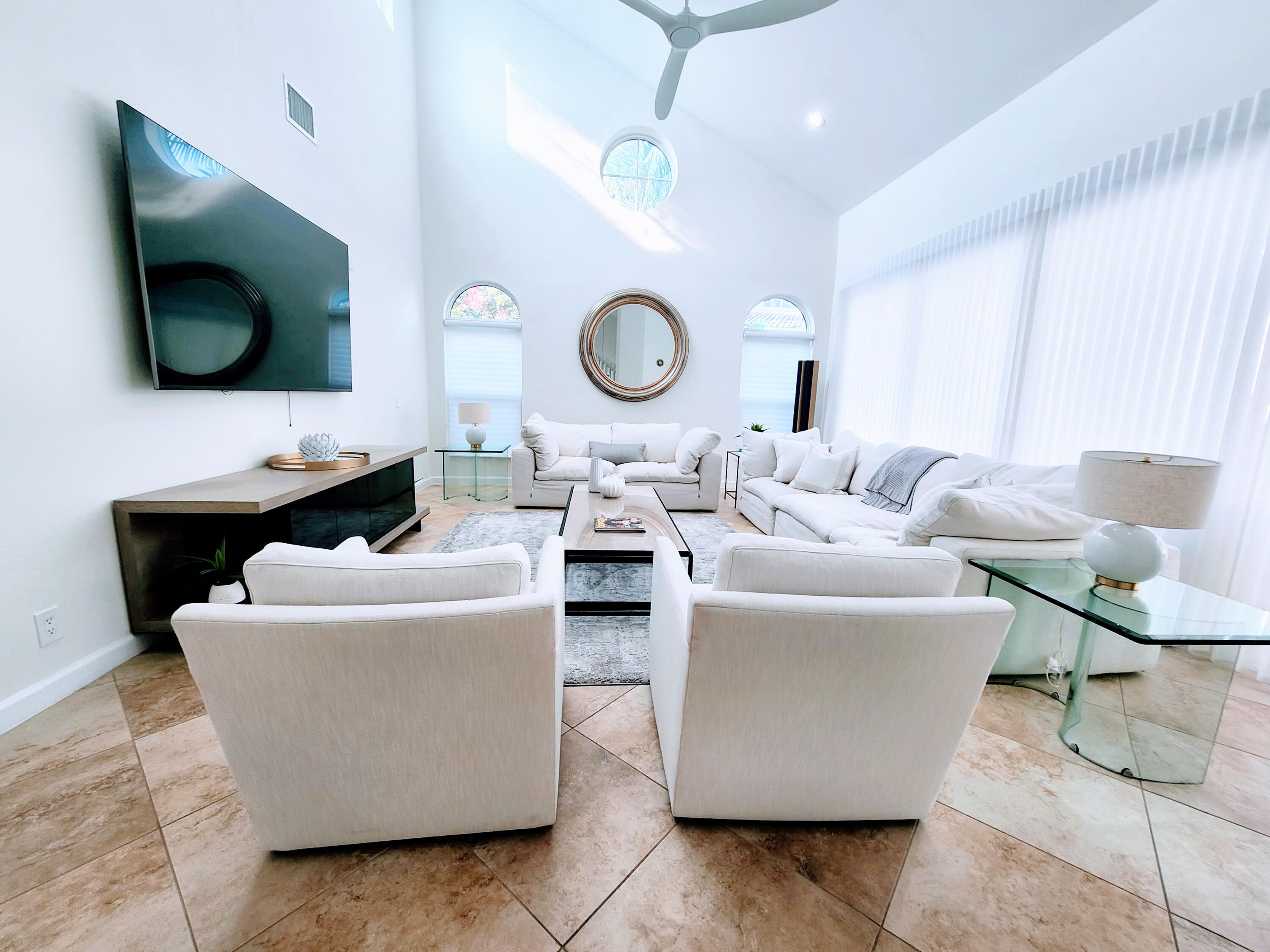 3567 Commodore Circle Delray Beach, FL 33483 - Photo 7 of 76 a living room with couches a flat screen tv and kitchen view