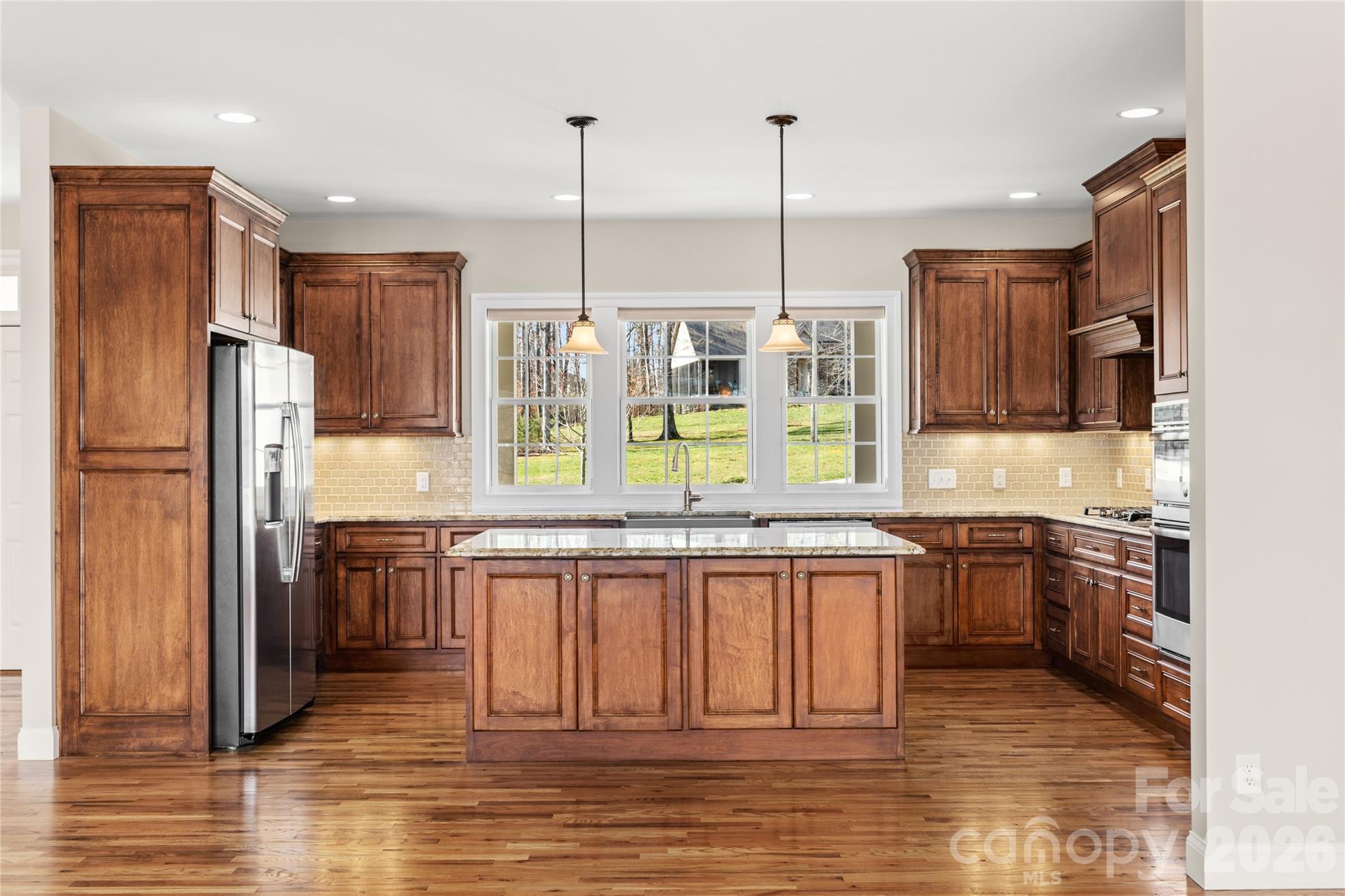 490 Mapleton Lane Columbus, NC 28722 - Photo 11 of 42 a kitchen with stainless steel appliances granite countertop a refrigerator a sink a stove and a wooden floors