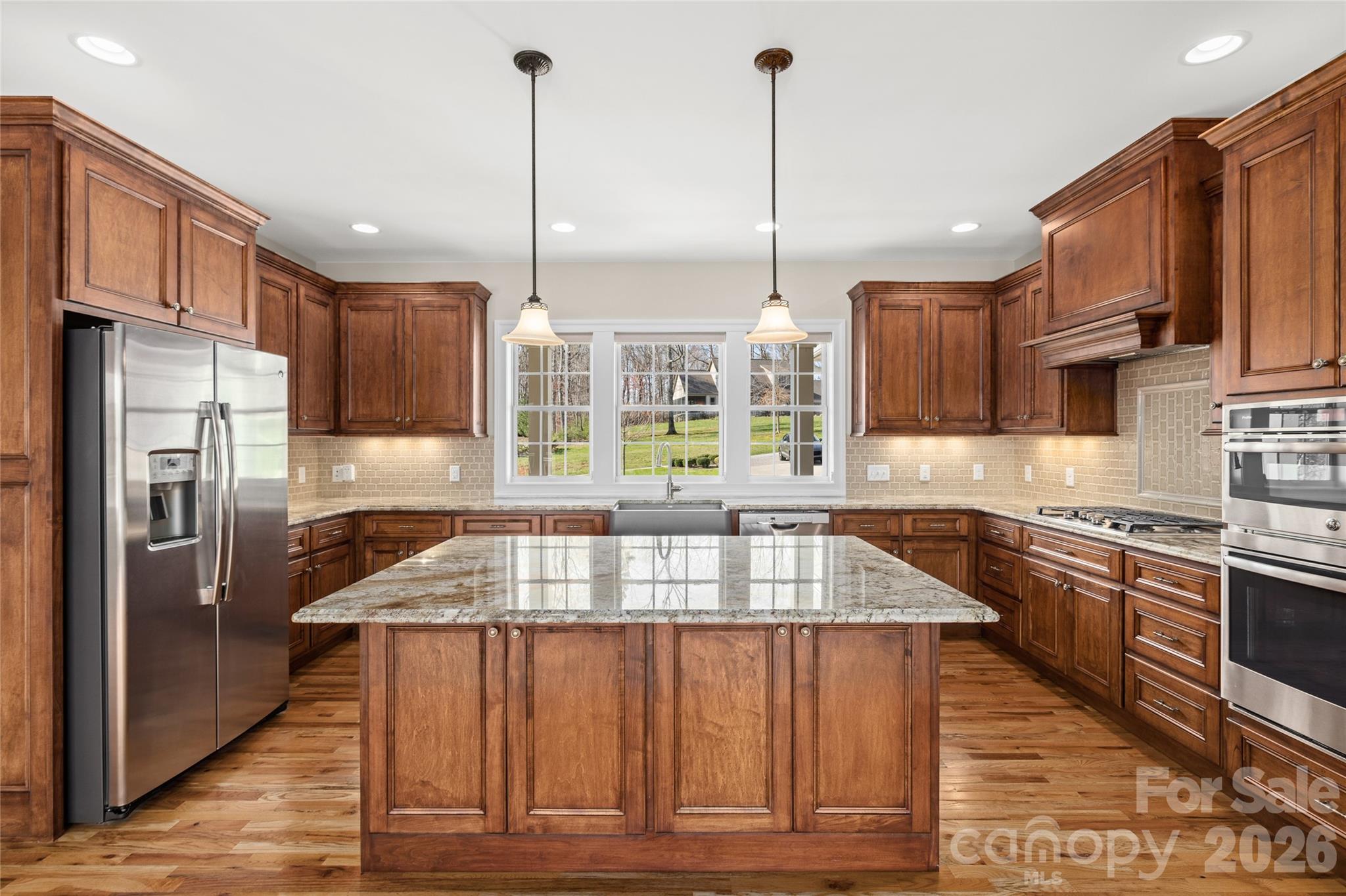 490 Mapleton Lane Columbus, NC 28722 - Photo 13 of 42 a kitchen with stainless steel appliances granite countertop a stove a sink dishwasher a refrigerator and a wooden cabinets