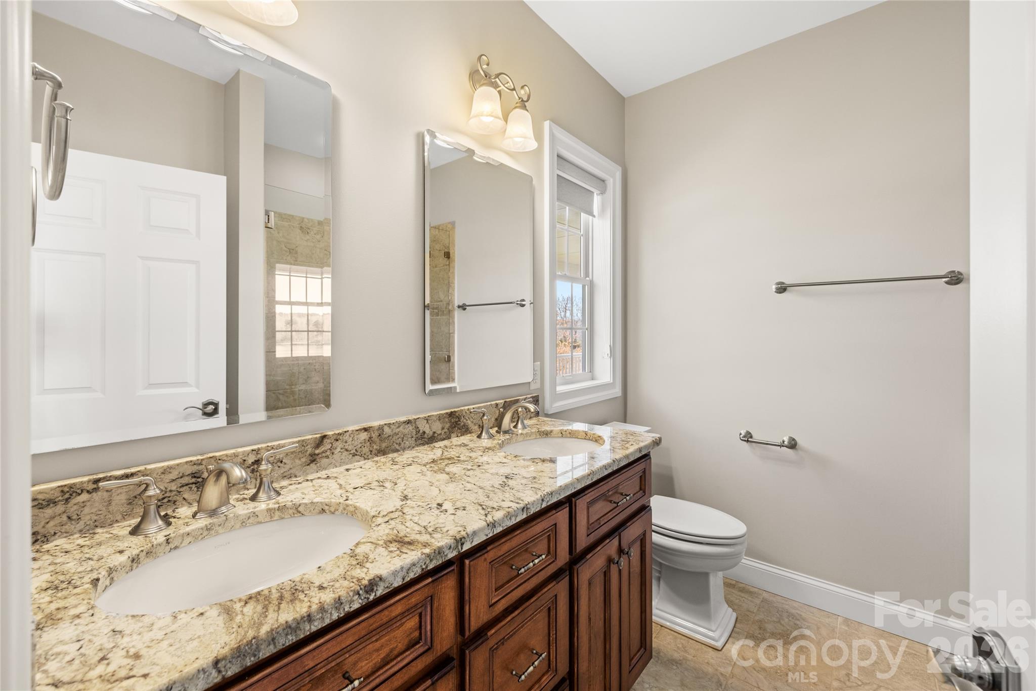 490 Mapleton Lane Columbus, NC 28722 - Photo 27 of 42 a bathroom with a granite countertop sink a large mirror and a toilet
