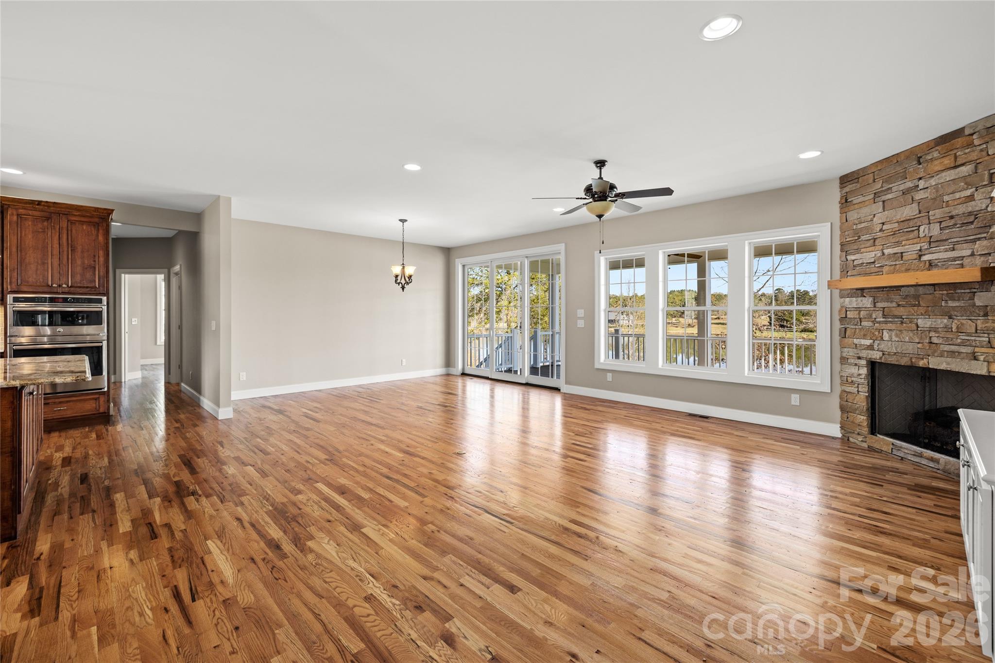 490 Mapleton Lane Columbus, NC 28722 - Photo 6 of 42 a view of an empty room with wooden floor fireplace and a window