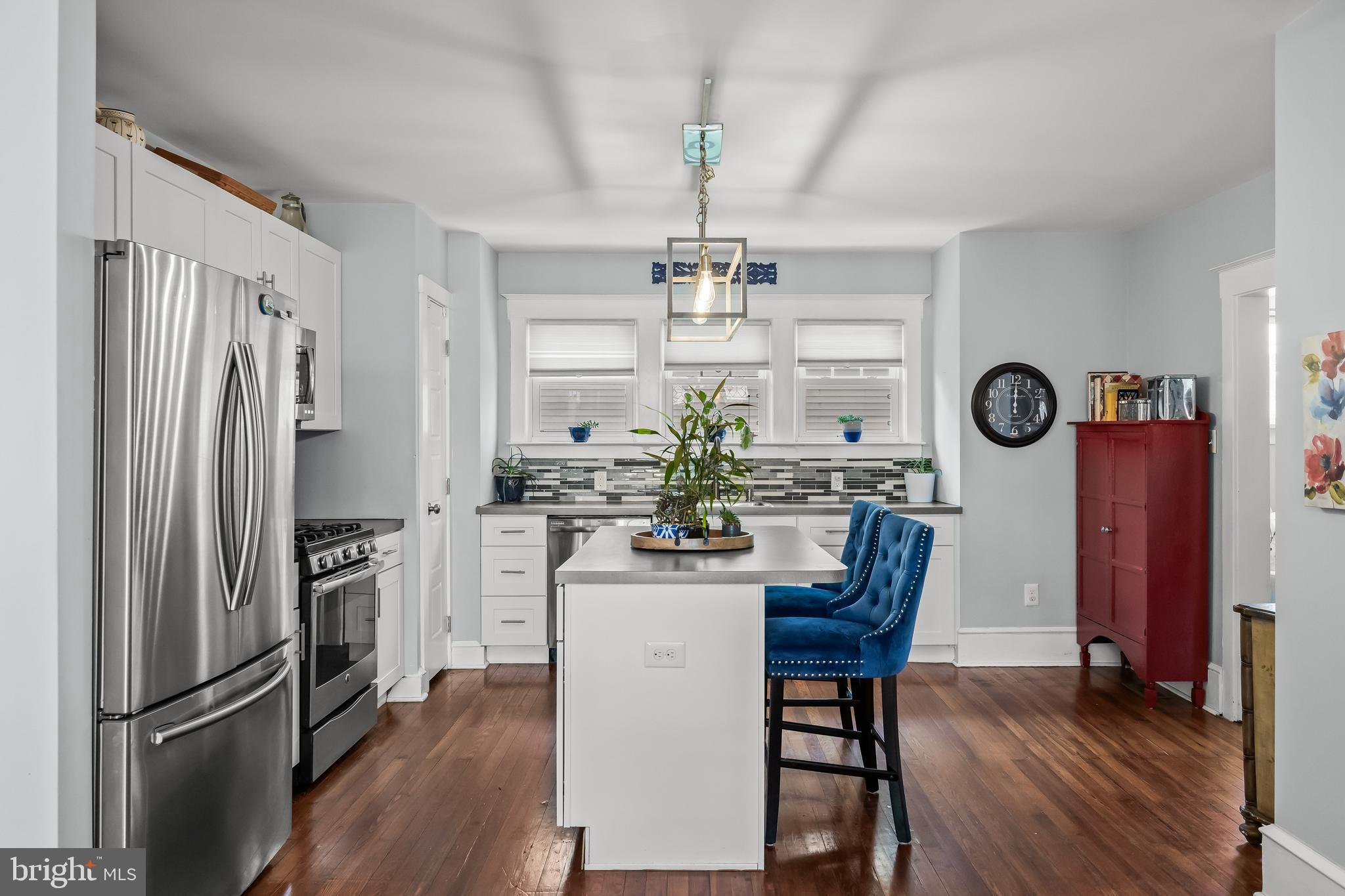 615 North Walnut Avenue Magnolia, NJ 08049 - Photo 12 of 40 a kitchen with refrigerator a stove a dining table and chairs with wooden floor