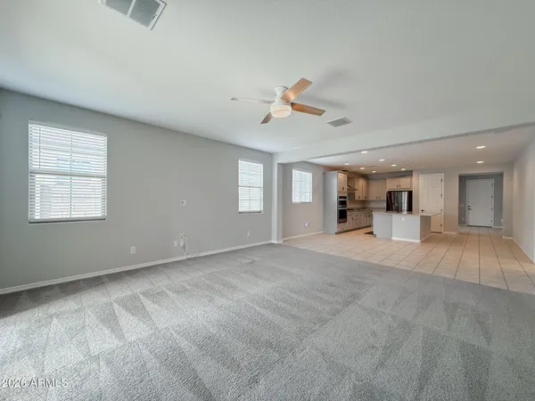 a view of a livingroom with wooden floor and a ceiling fan