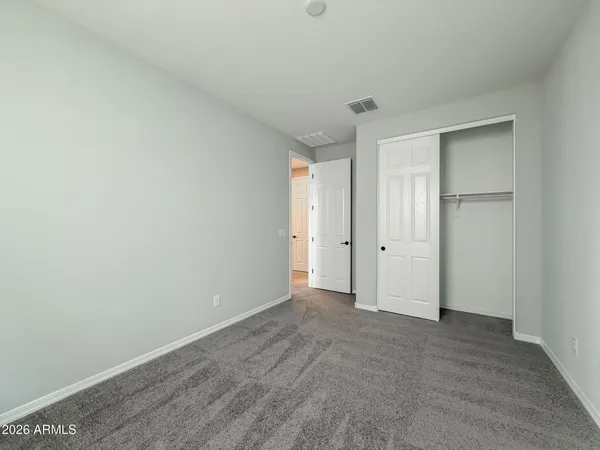 an empty room with windows and closet