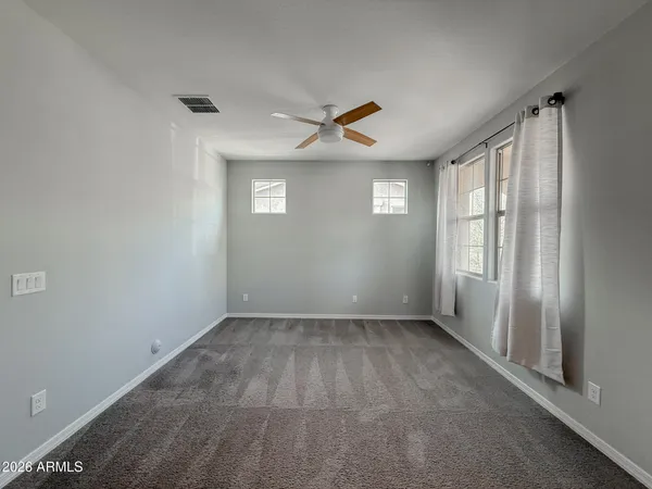 an empty room with a ceiling fan and window