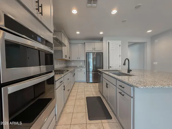 a kitchen with stainless steel appliances granite countertop a refrigerator and a sink