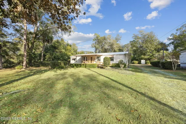 a view of yard with swimming pool and trees