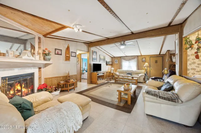 a living room with furniture fireplace and a large window