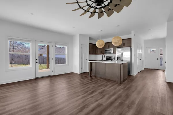 a view of a kitchen center island wooden floor and stainless steel appliances