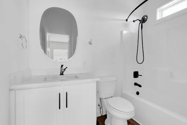 a bathroom with a granite countertop sink a toilet and a mirror