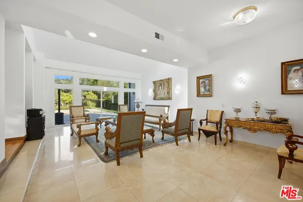 a living room with furniture a large window and a flat screen tv