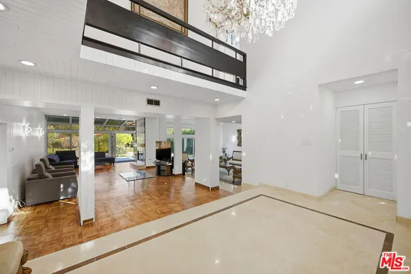 a spacious bedroom with a bed and a chandelier