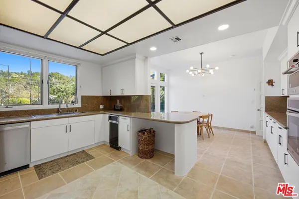 a kitchen with stainless steel appliances kitchen island granite countertop a table and chairs in it