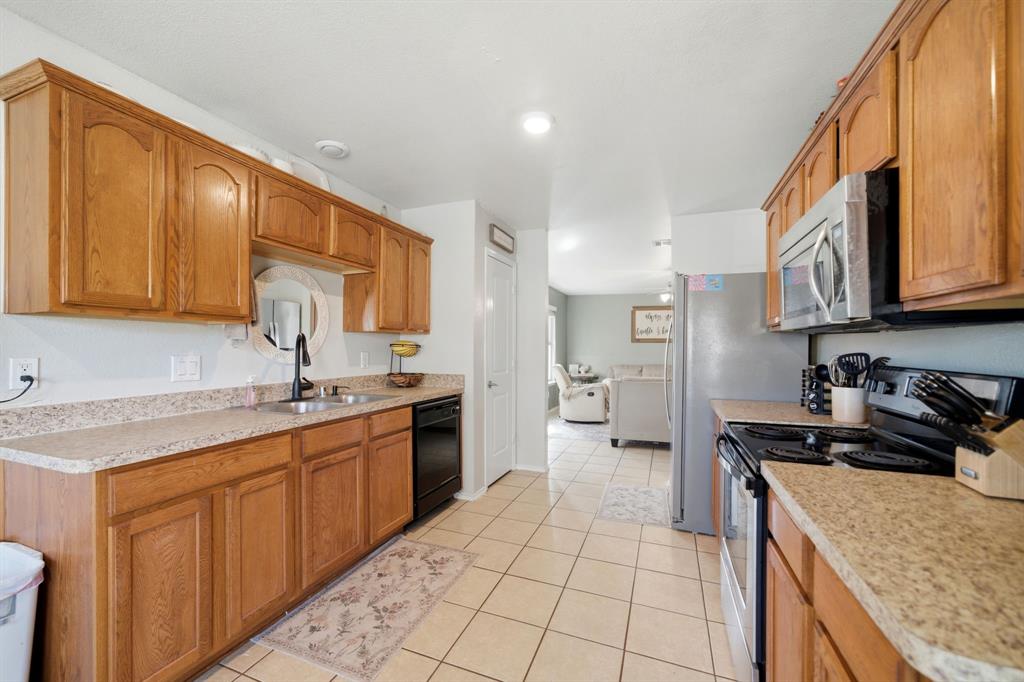 2008 Times Road Heartland, TX 75126 - Photo 14 of 28 a kitchen with stainless steel appliances granite countertop a sink stove refrigerator and cabinets