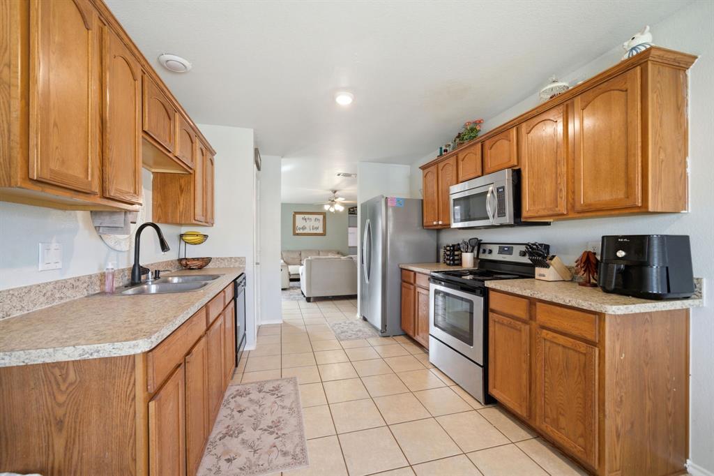 2008 Times Road Heartland, TX 75126 - Photo 15 of 28 a large kitchen with stainless steel appliances granite countertop a stove a sink dishwasher and a refrigerator