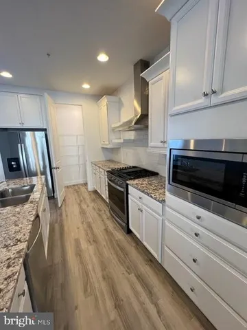 a kitchen with granite countertop a stove a sink and a refrigerator