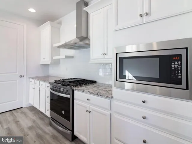 a kitchen with stainless steel appliances white cabinets and stove