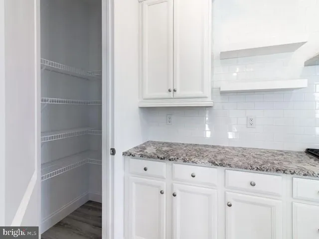 a kitchen with granite countertop white cabinets and a sink