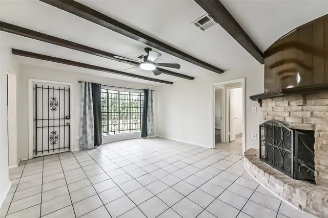 a view of an empty room with a fireplace and a window