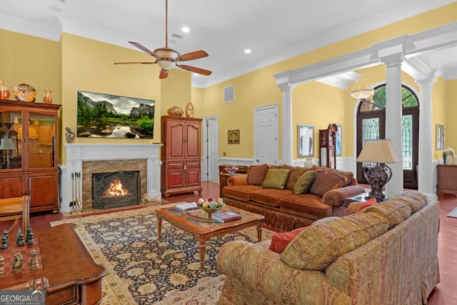 a living room with furniture a fireplace and a chandelier