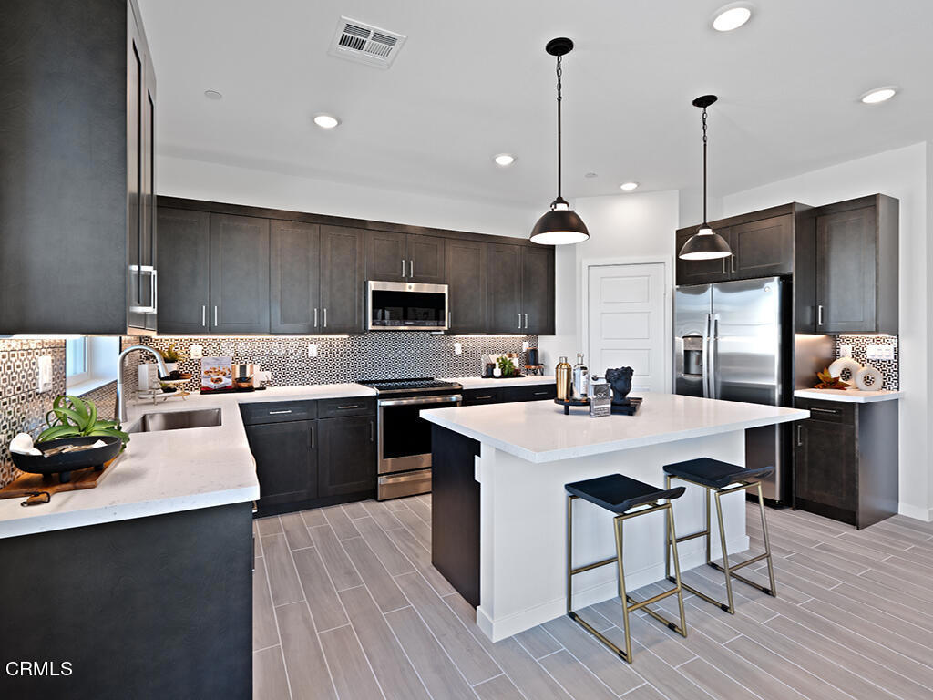 3822 Silvergrass Lane Piru, CA 93040 - Photo 2 of 24 a kitchen with granite countertop a sink a counter top space stainless steel appliances and cabinets