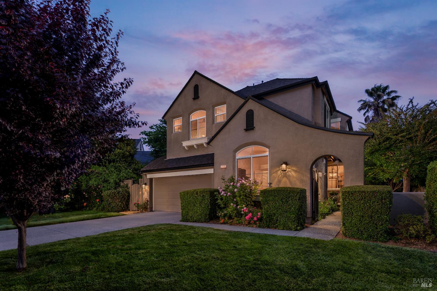 a front view of a house with a garden and plants