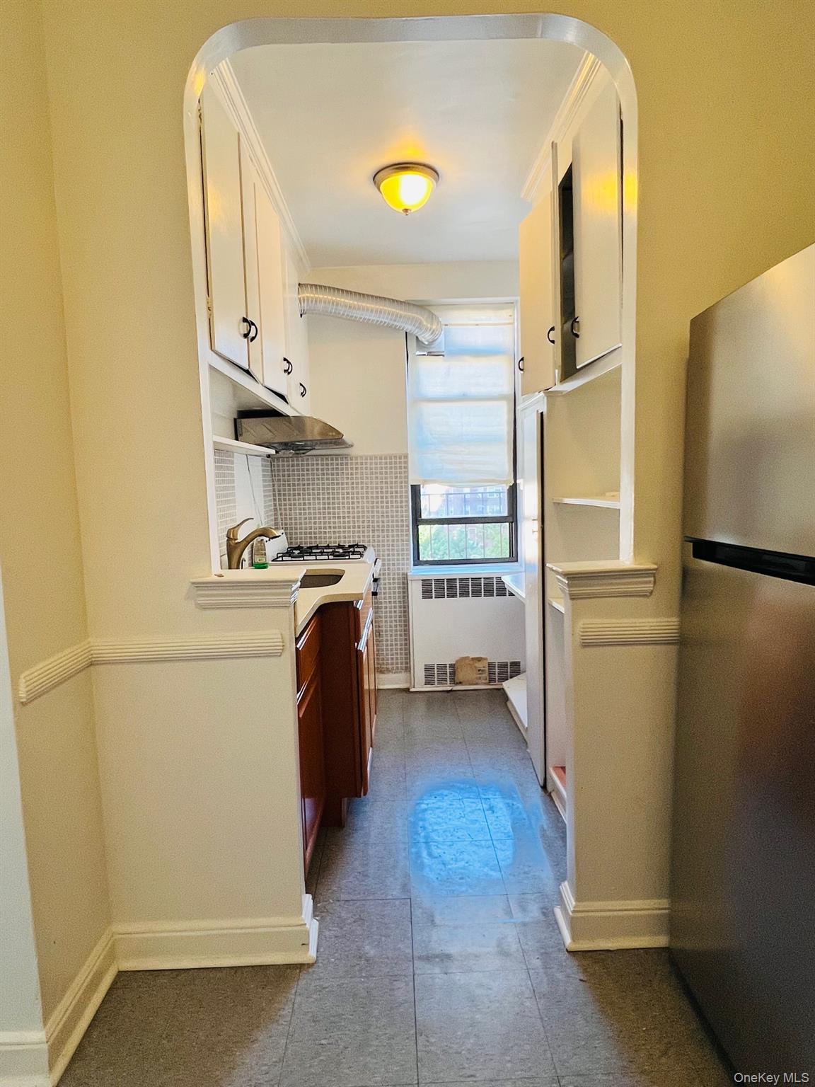 67-35 Yellowstone Boulevard, Unit 7E Queens, NY 11375 - Photo 12 of 16 a kitchen with a refrigerator and cabinets