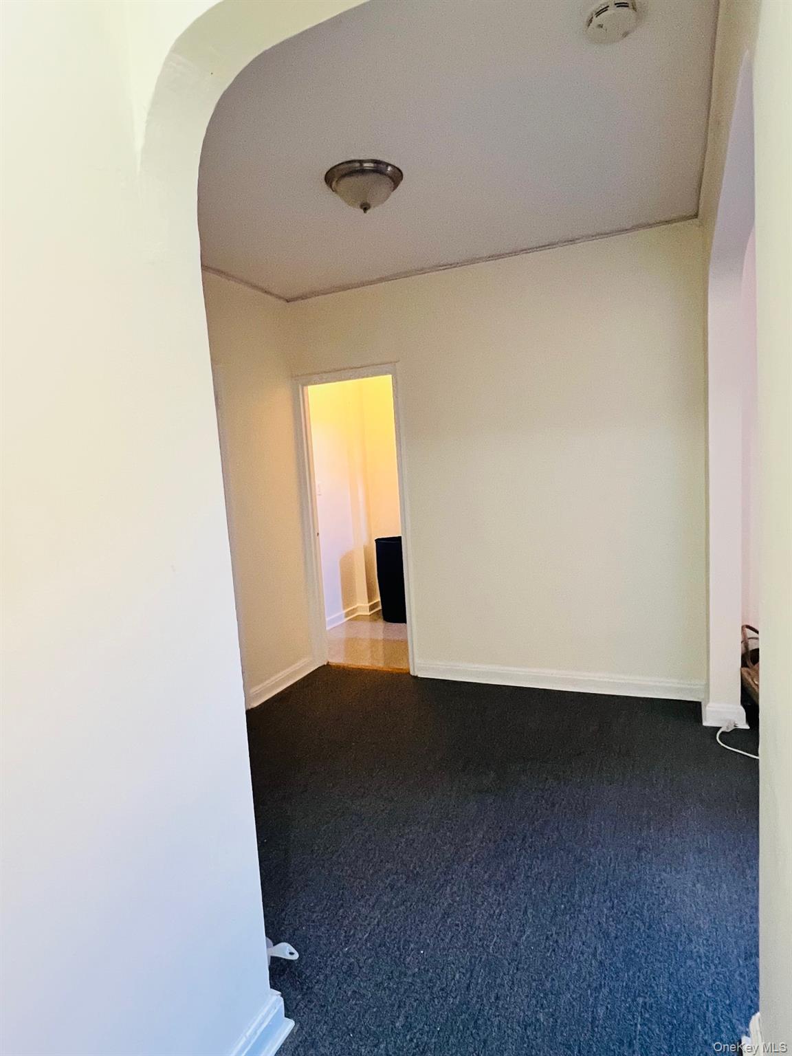 67-35 Yellowstone Boulevard, Unit 7E Queens, NY 11375 - Photo 7 of 16 an empty room with wooden floor and windows