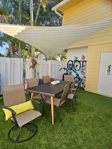 a view of a patio with table and chairs with wooden fence and plants