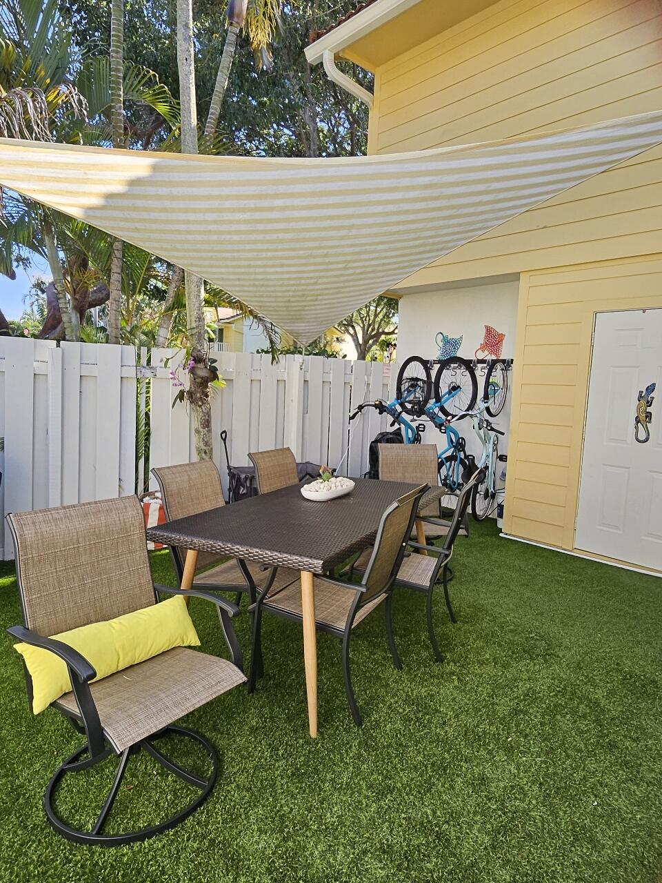226 Seabreeze Circle Jupiter, FL 33477 - Photo 1 of 22 a view of a patio with table and chairs with wooden fence and plants